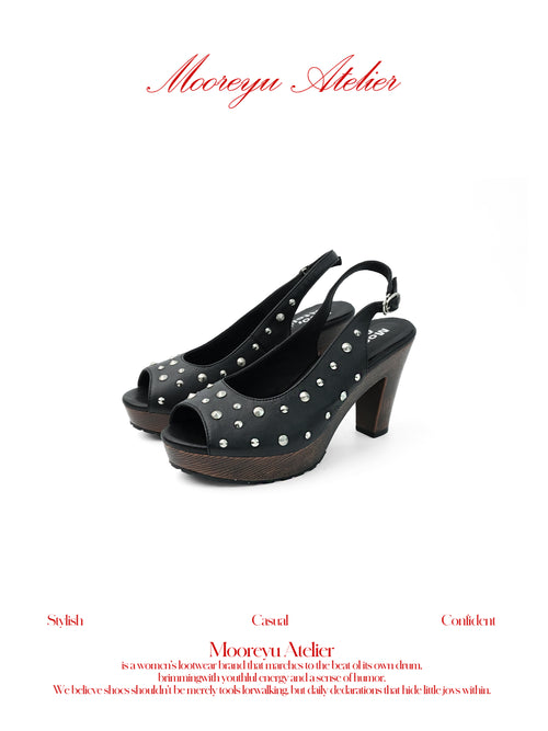 White background studio shot of MOOREYU ATELIER punk black full grain leather slingback sandals, peep toe silver round studs, 10cm faux wood grain platform block heels