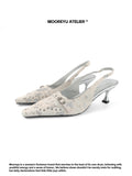 Cream beige MOOREYU ATELIER spotted horsehair slingback pumps, 6cm thin stiletto pointed heels with silver rivet buckle, front view on white background