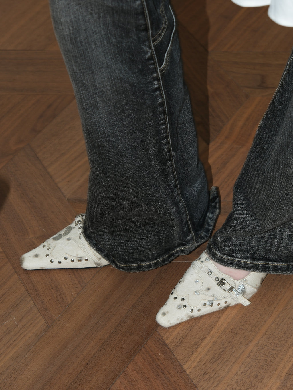 Close shot of woman’s feet in MOOREYU beige horsehair pointed slingback heels, indoor minimalist scene